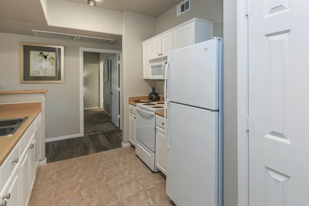 Kitchen with white appliances at The Covington by Picerne, Nevada, 89139