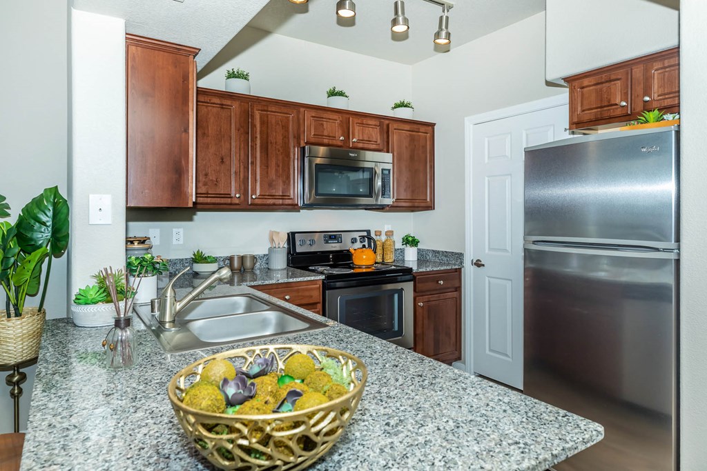 Wooden cabinets and appliances in kitchen at The Equestrian by Picerne, Henderson, NV