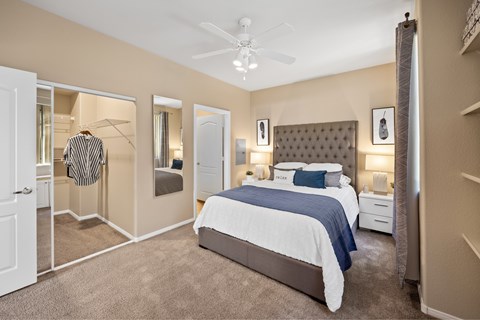 A bedroom with a large bed and a ceiling fan. at The Fairways by Picerne Apartments, Las Vegas, NV, 89141