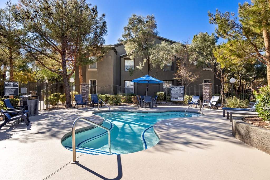 A pool surrounded by trees at The Equestrian by Picerne Apartments, Henderson 89052