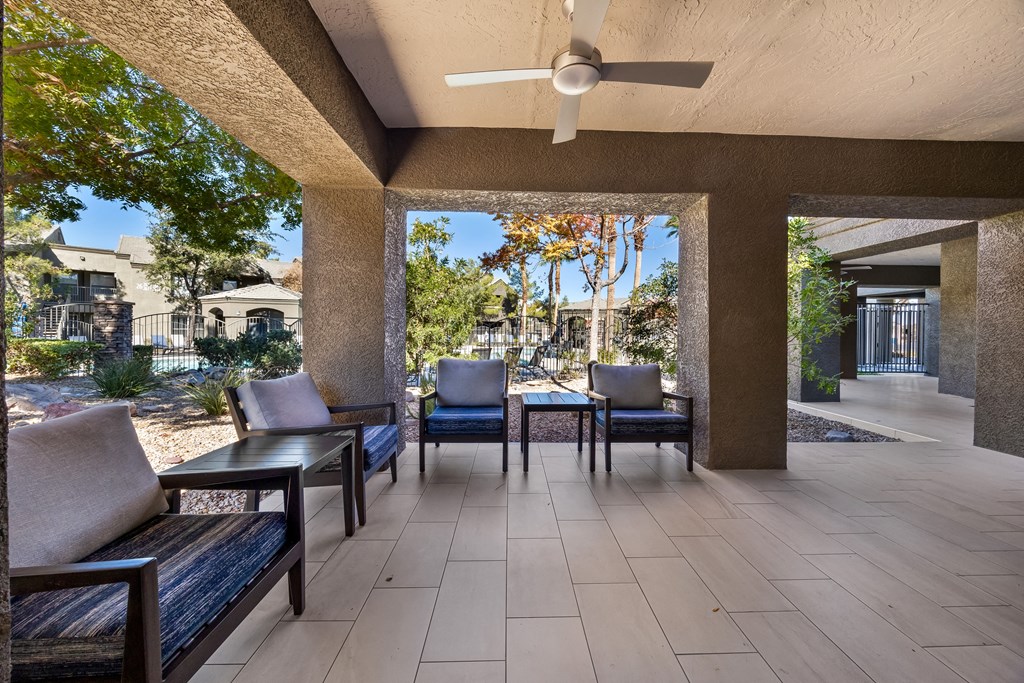 A patio with a table and chairs is shown at The Equestrian by Picerne Apartments, Henderson, NV