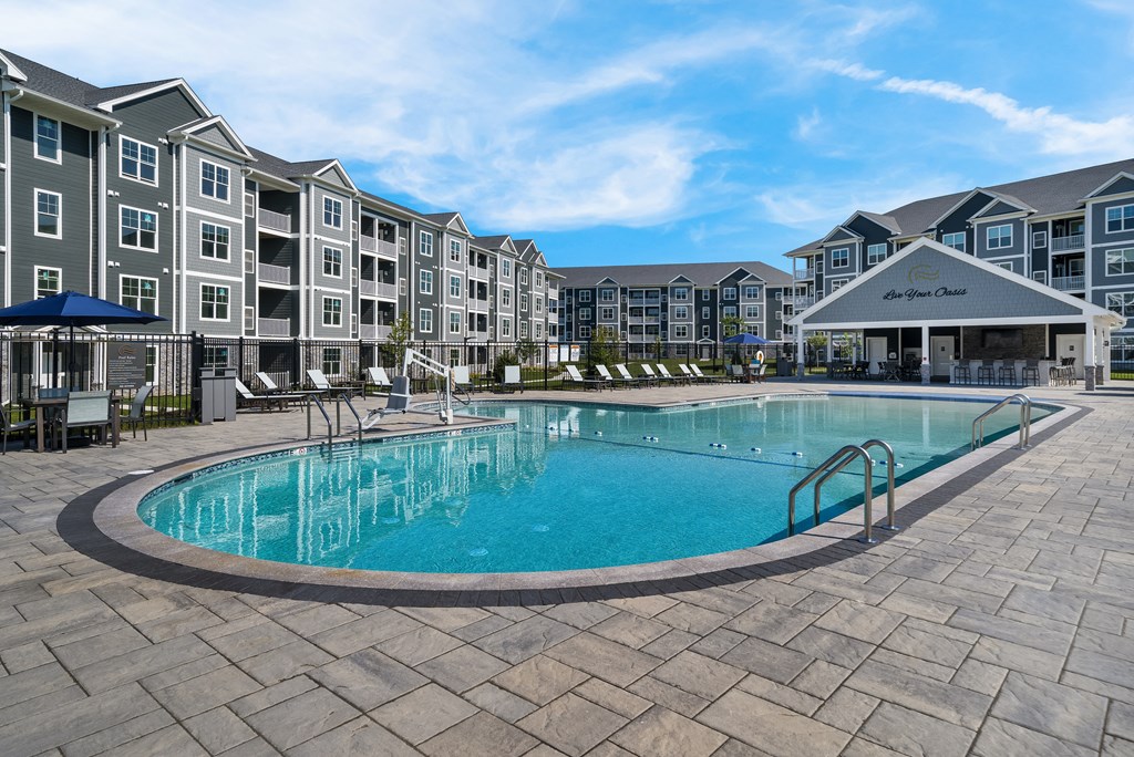a swimming pool with an apartment building in the background