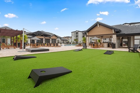 A lawn with a hole in the middle and a pavilion in the background.