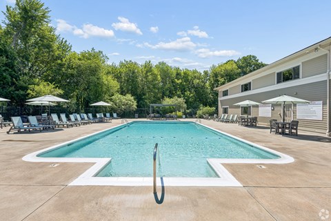 A large outdoor swimming pool with a white arrow painted on the bottom.