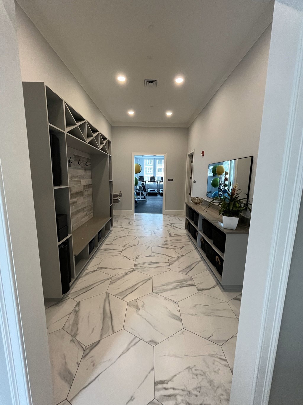 a look down the hallway of a house with a marble tiled floor at The Oasis at Plymouth, Plymouth, MA