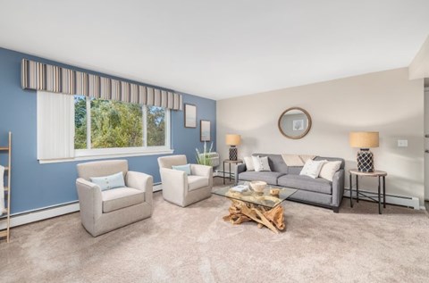 A living room with a grey couch, two armchairs, and a coffee table.