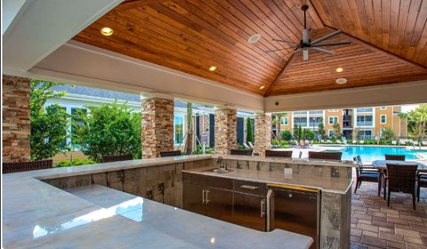 A modern outdoor kitchen with a pool.