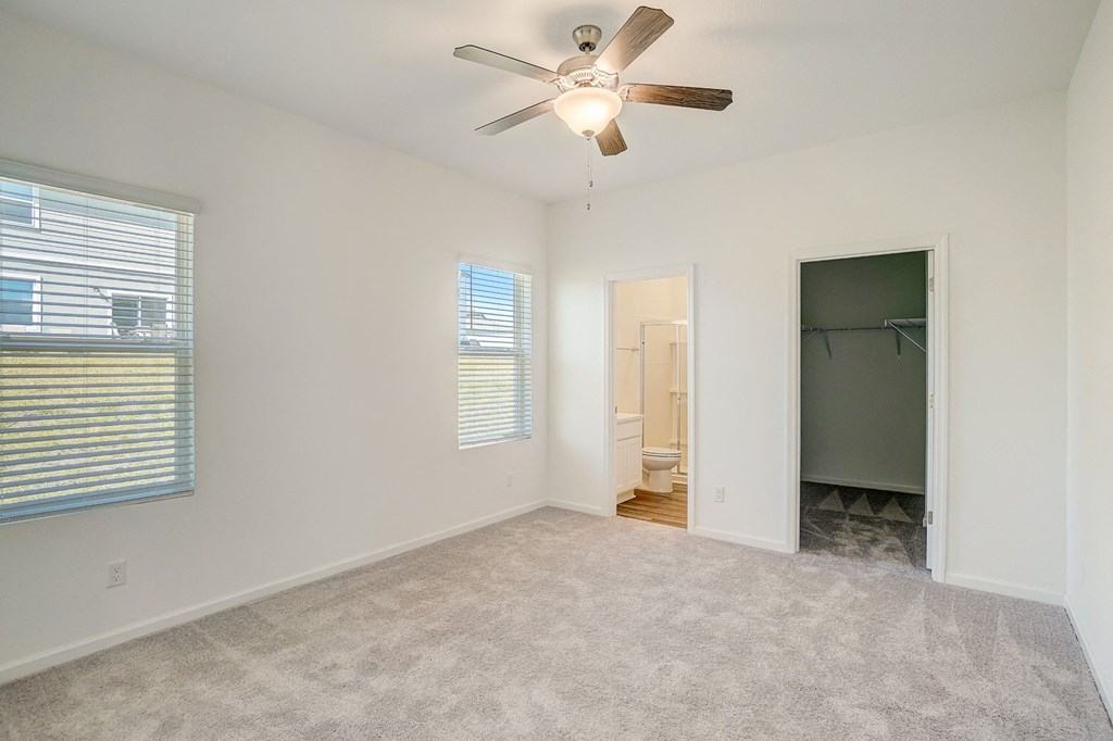 Bedroom with plush carpeting and ceiling fan in the Elm floor plan at Beacon at Clinton Corners in Dade City, FL