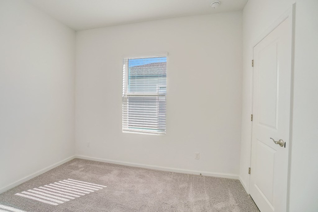 Bedroom with window and closet door in the Oak floor plan at Beacon at Clinton Corners in Dade City, FL
