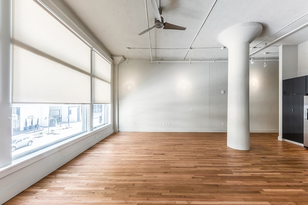 Mid Elm Lofts room with wood floors and a large window