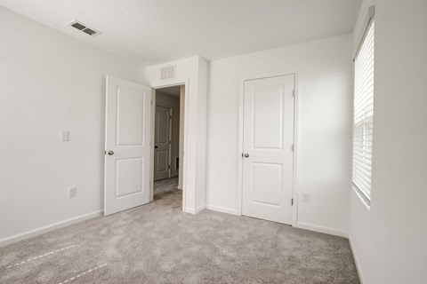 View of second bedroom with white doors and a carpeted floor at Beacon at Arbours in Ruskin, FL
