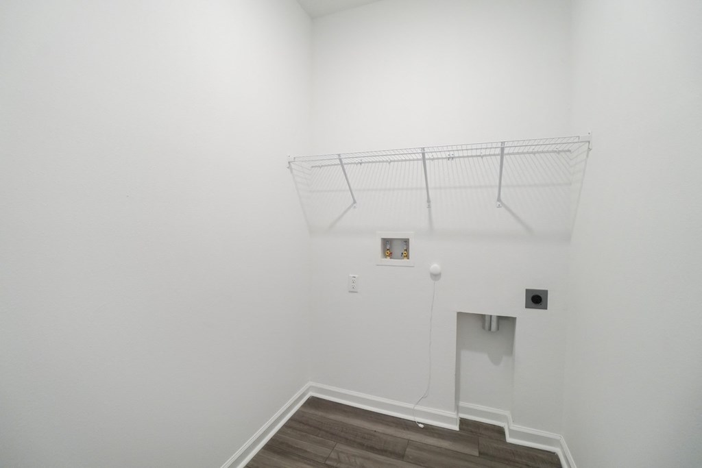 Laundry room with a shelf and full-size washer and dryer connections in the Oak floor plan at Beacon at Clinton Corners in Dade City, FL