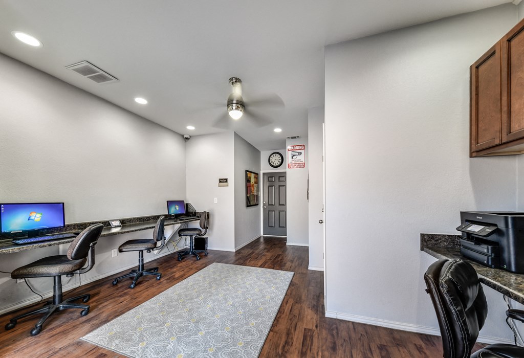 a living room with two desks and a tv
