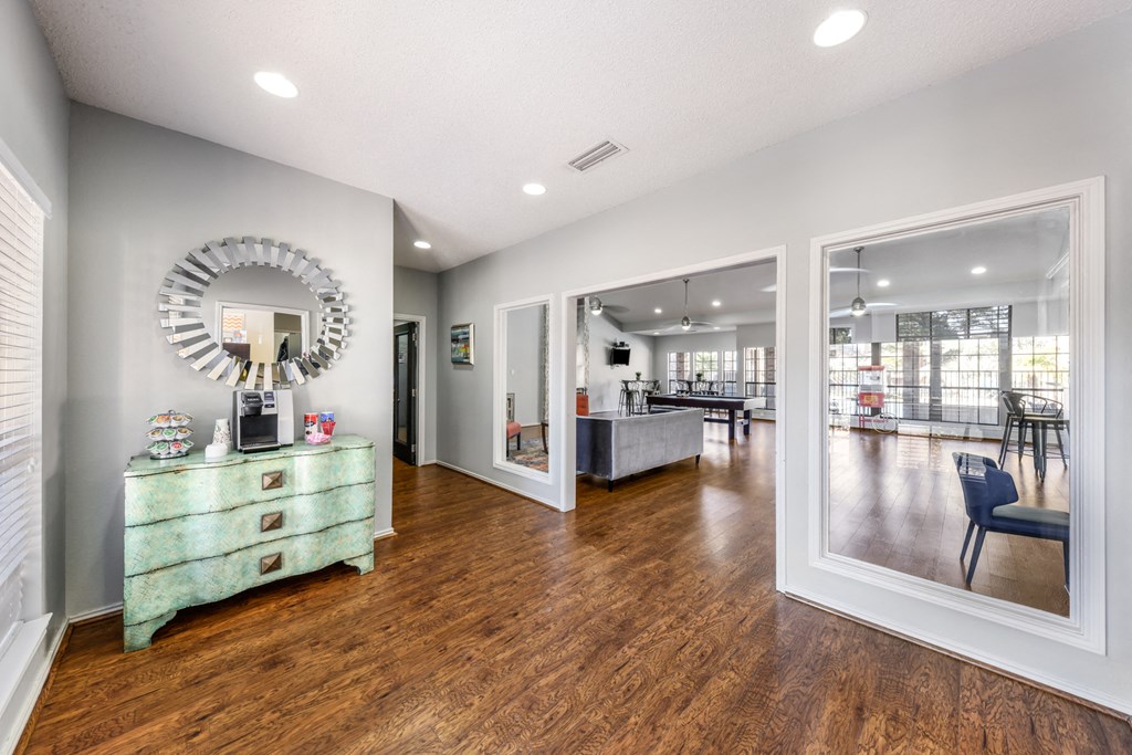 a living room with a mirror and a dresser