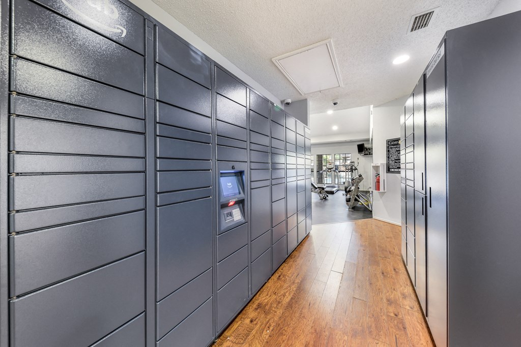 a long hallway with gray lockers and a wood floor
