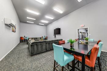 Media room with A/C, large couch, TV, and seating at Camino del Sol in Denton, TX