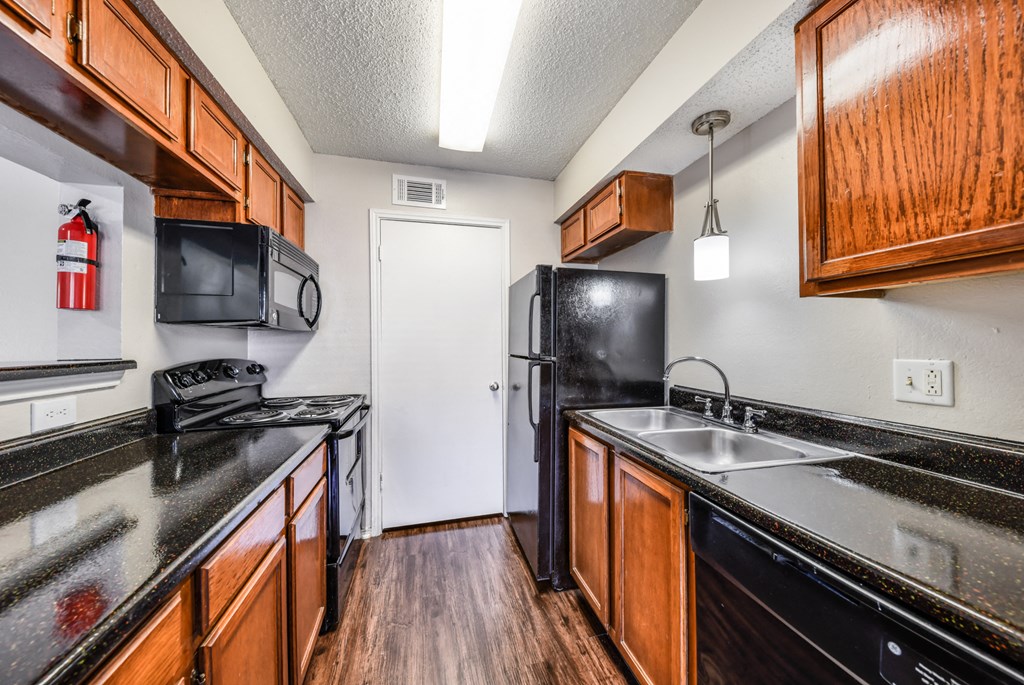 a kitchen with black appliances and wooden cabinets