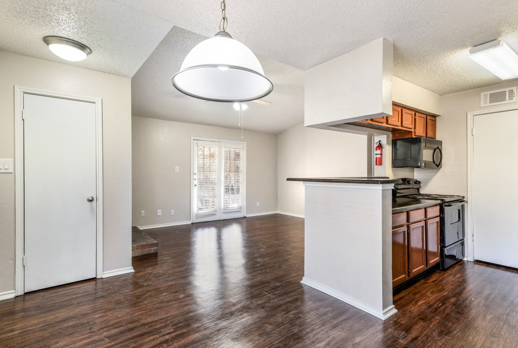 an empty kitchen and living room with a door to a closet