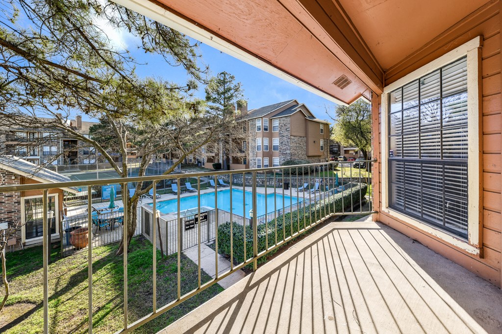 the outlook of the pool from the balcony of a house with a pool