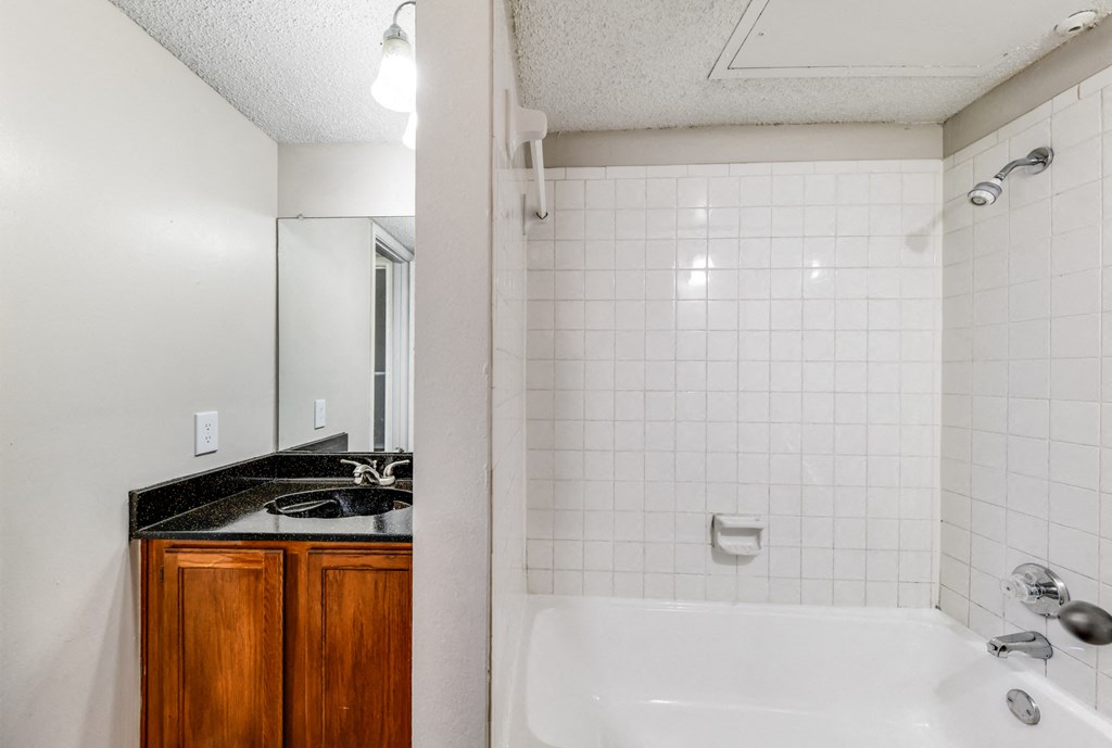 a bathroom with a sink and a tub and a shower