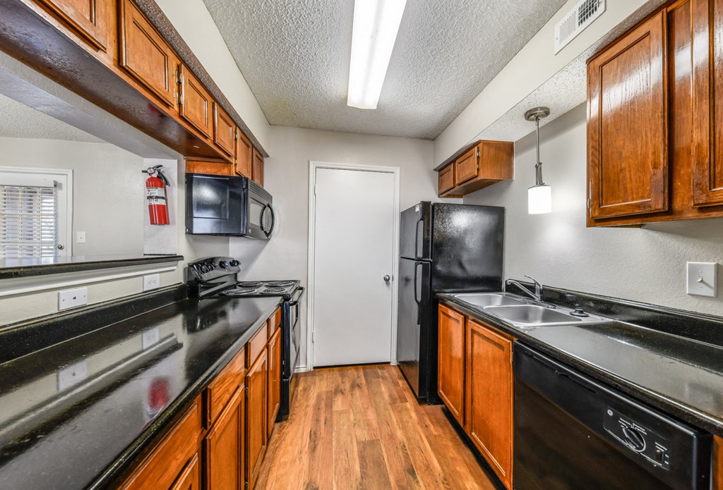 a kitchen with black appliances and wooden cabinets