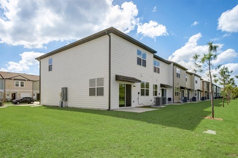 View behind our townhomes with a green lawn area at Beacon at Arbours in Ruskin, FL