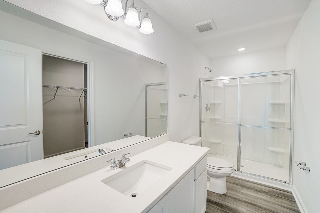 A bathroom with a sink and a stand-up shower in the Verbena floor plan at Beacon at Clinton Corners in Dade City, FL