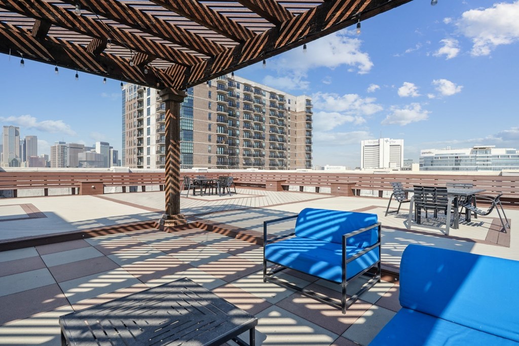 3200 Main rooftop patio with blue couches and view of the Downtown Dallas skyline in the background | Deep Ellum Lofts in Dallas, TX