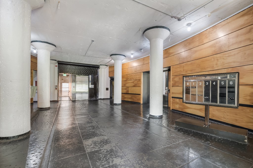 a large hallway with white pillars and a wood paneled wall