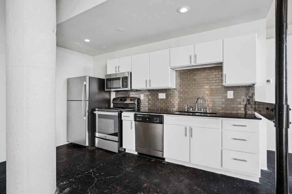 a kitchen with white cabinets and stainless steel appliances