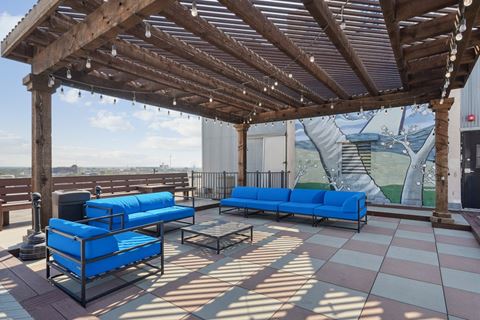 a patio with blue couches and chairs on a roof