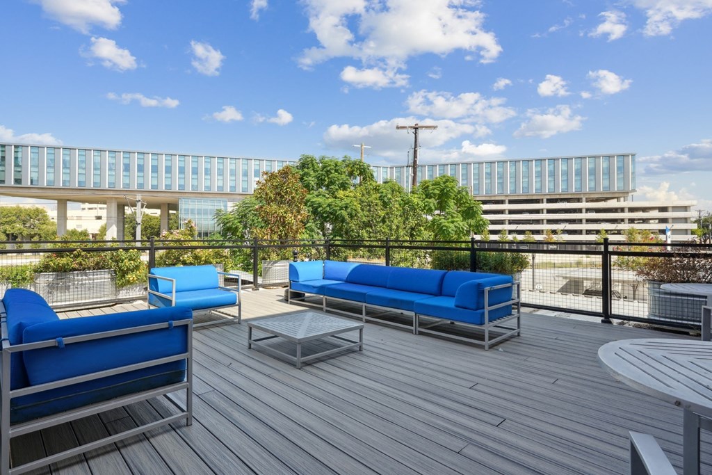 Rooftop deck with blue couches and a coffee table | Deep Ellum Lofts in Dallas, TX