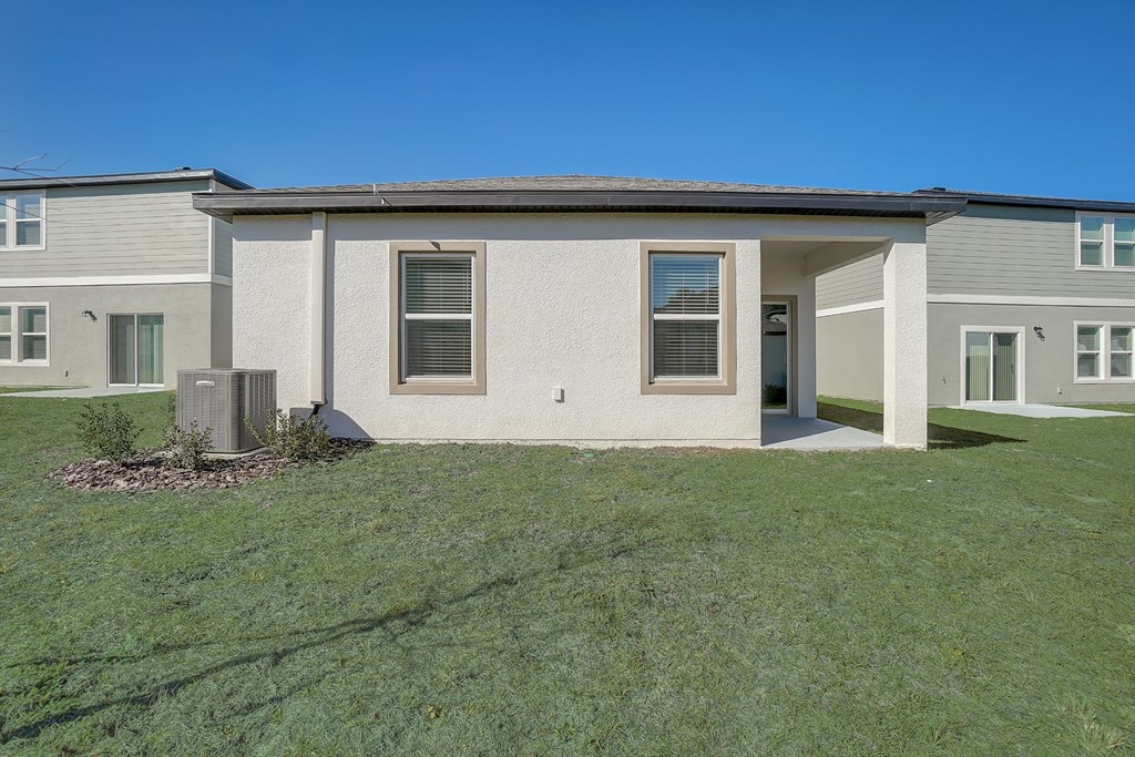 Backyard with lush green grass of the Oak floor plan at Beacon at Clinton Corners in Dade City, FL