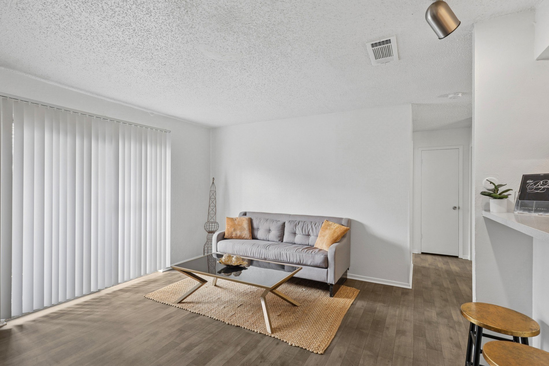 A living room with a grey couch and a wooden coffee table.
