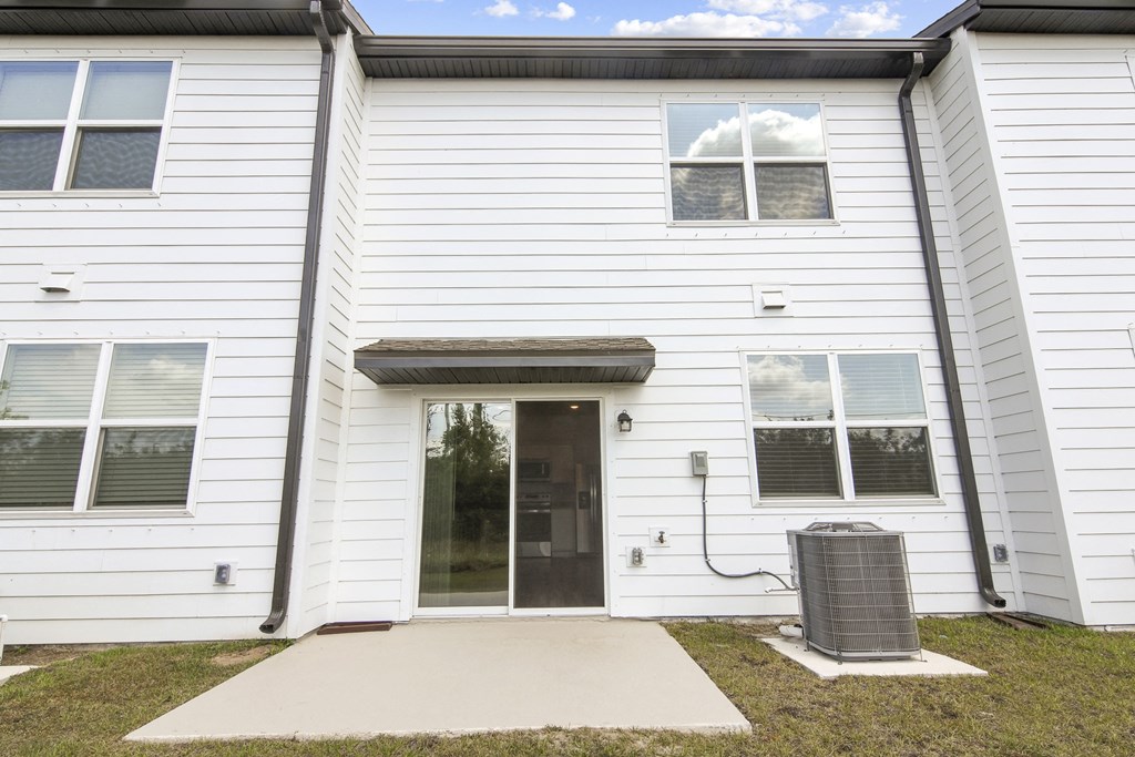 a white building with a black door and a grey trash can in front of it at Beacon at Arbours, Ruskin