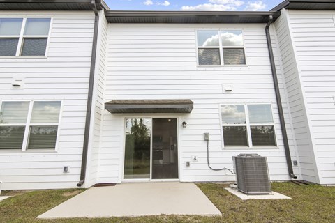 a white building with a black door and a grey trash can in front of it at Beacon at Arbours, Ruskin