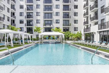 Tropical pool deck with large sundeck and cabanas at Alameda West, Miami, FL