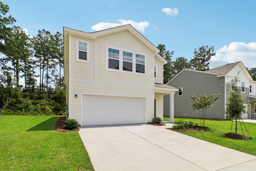 Entrance view of the house with a driveway and landscaped garden at Beacon at Ashley River Landing in Summerville, SC