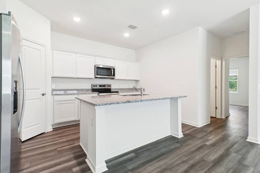 Modern kitchen with stainless steel appliances and white cabinetry at Beacon at Ashley River Landing in Summerville, SC