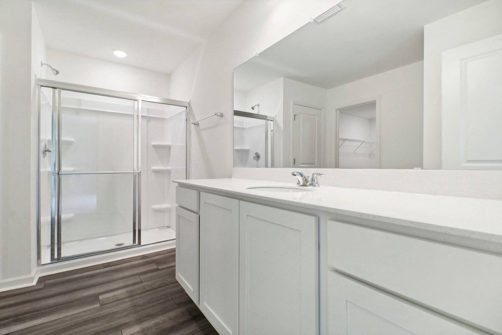 Elegant bathroom with a walk-in shower and white vanity at Beacon at Ashley River Landing in Summerville, SC