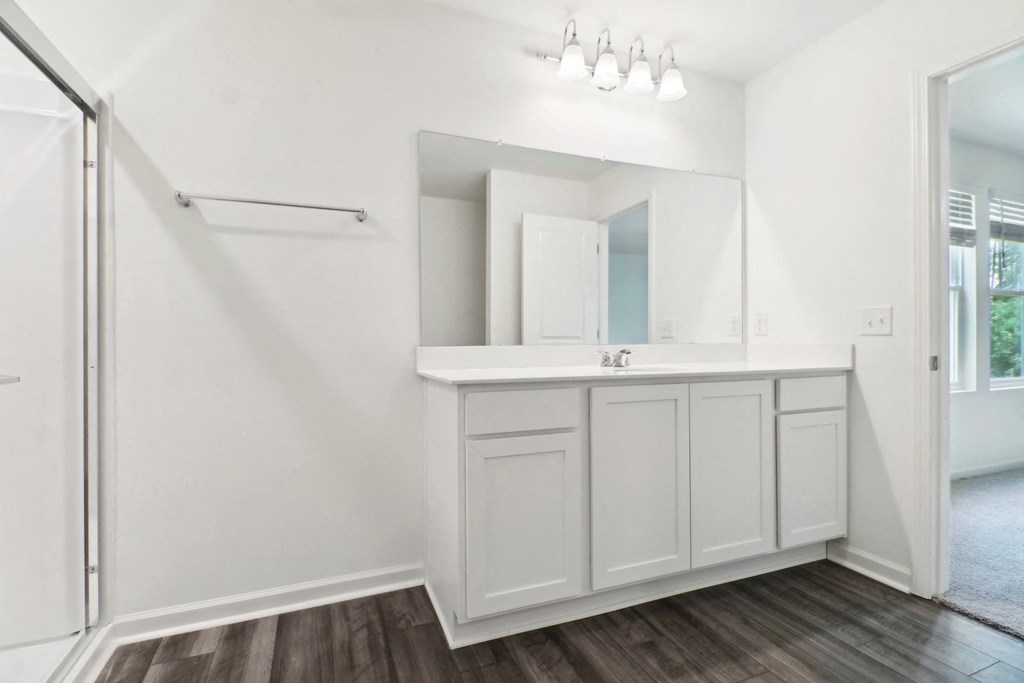 White sink vanity with a large mirror in the master bathroom at Beacon at Ashley River Landing in Summerville, SC