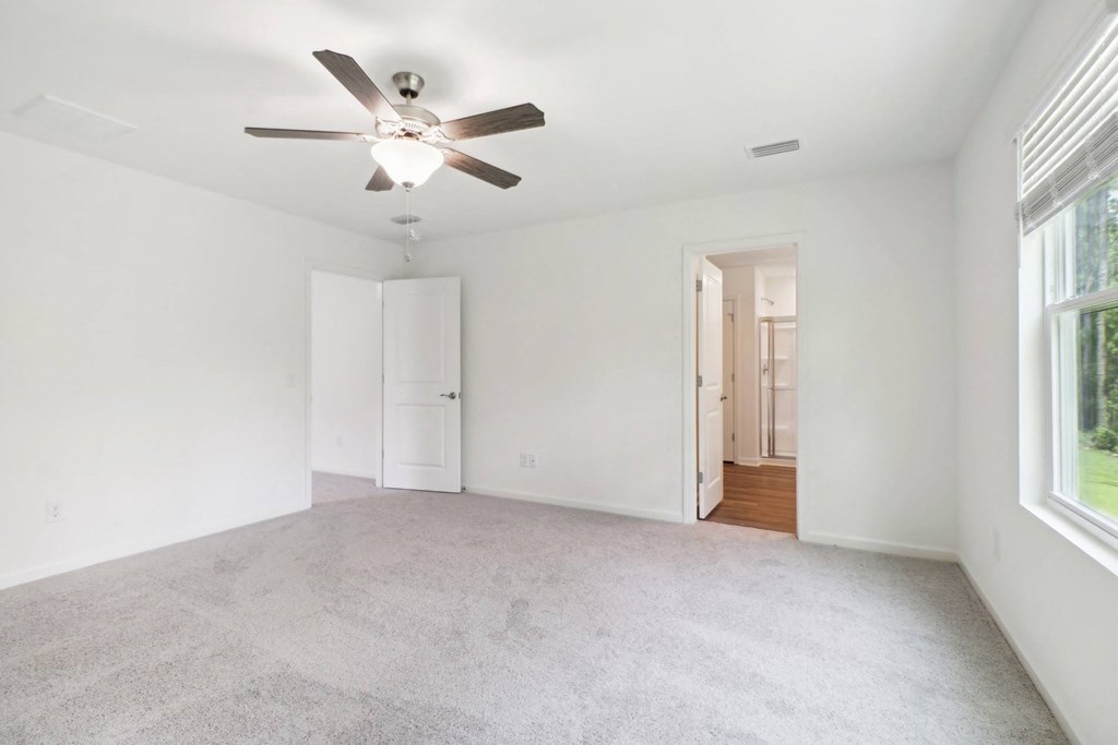 Master bedroom with ceiling fan and carpeted flooring at Beacon at Ashley River Landing in Summerville, SC