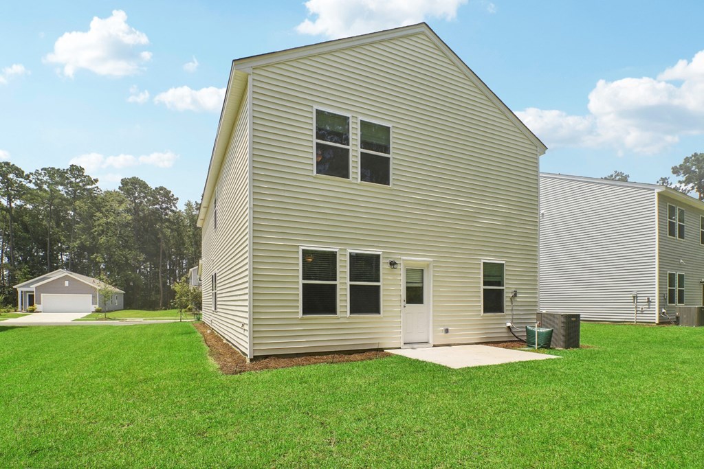 Front exterior view of a modern home with a landscaped yard at Beacon at Ashley River Landing in Summerville, SC