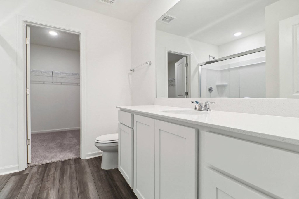 Maple bathroom with white cabinetry and a large mirror at Beacon at Ashley River Landing in Summerville, SC