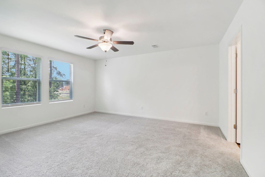 Spacious master bedroom with carpet floor and ceiling fan at Beacon at Ashley River Landing in Summerville, SC