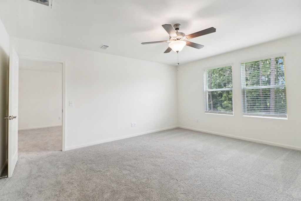 Maple master bedroom with ceiling fan and carpet flooring at Beacon at Ashley River Landing in Summerville, SC