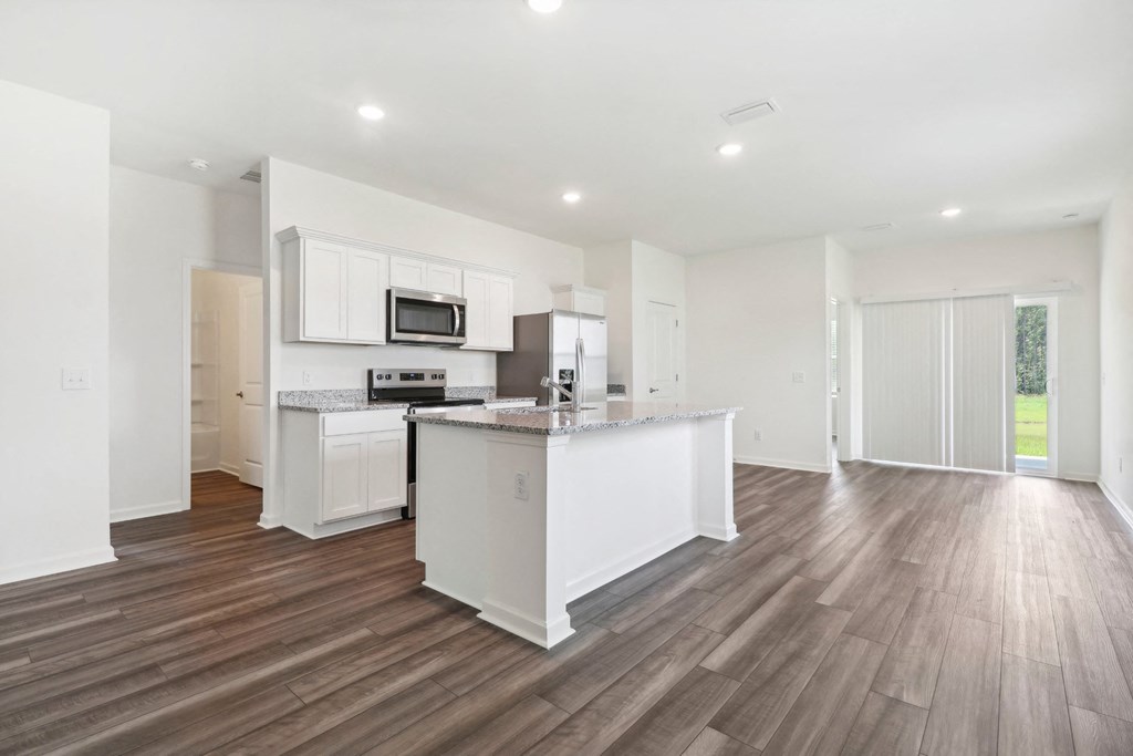 Oak open kitchen and living room with white cabinets and a counter top at Beacon at Ashley River Landing in Summerville, SC