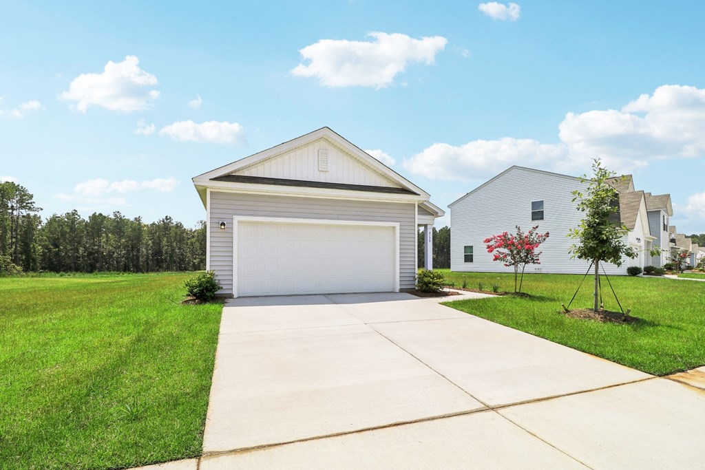 Oak front view with a white garage and a driveway at Beacon at Ashley River Landing in Summerville, SC