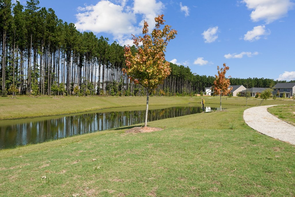 Pond and a walking trail leading from pool to houses at at Beacon at Ashley River Landing in Summerville, SC