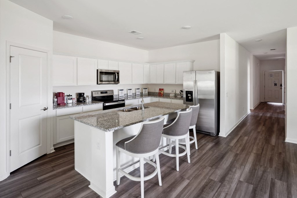 Kitchen with an island, granite countertops, and stainless steel appliances in the Poplar floor plan at Beacon at Ashley River Landing in Summerville, SC